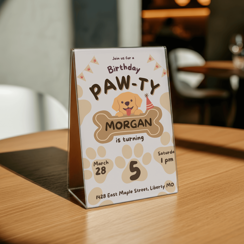 Birthday party invitation for a dog named Morgan on a wooden table.