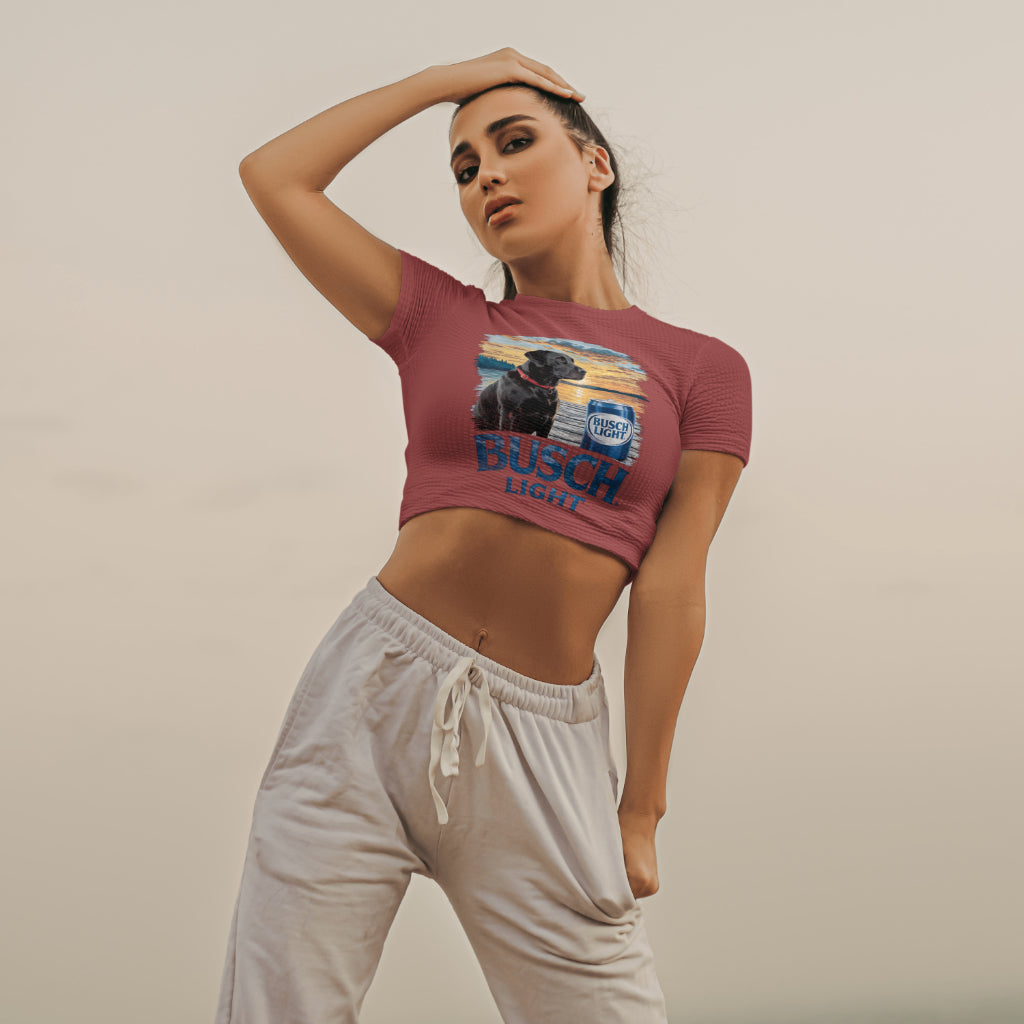 Black Lab sitting next to a Busch Light can on a wooden dock
