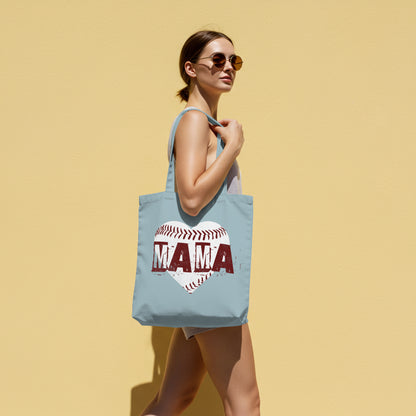 Woman holding a light blue tote bag with 'MAMA' design against a yellow background