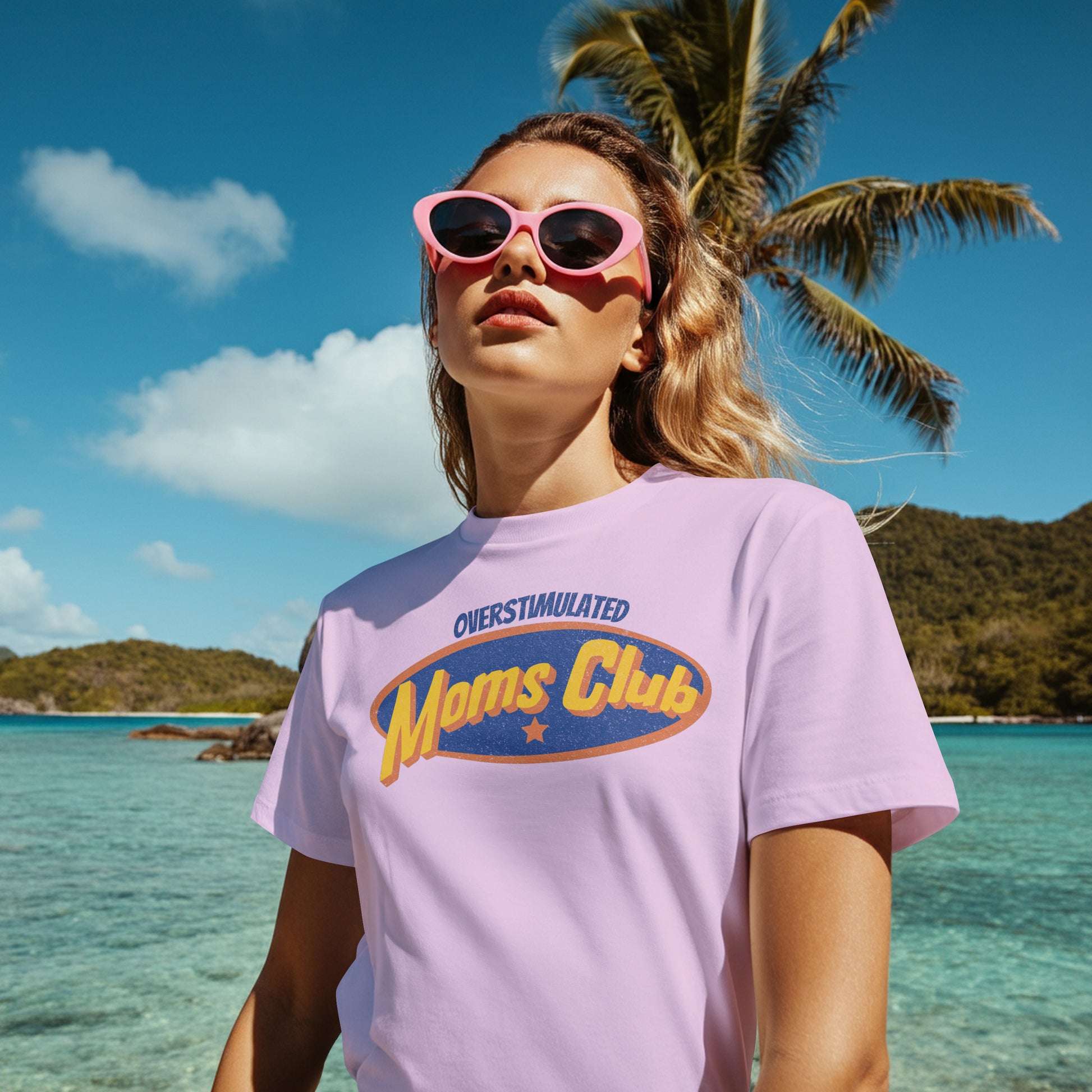 Woman wearing a 'Moms Club' t-shirt with sunglasses on a tropical beach.