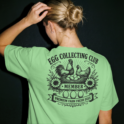 Person wearing a green t-shirt with 'Egg Collecting Club' design on the back.