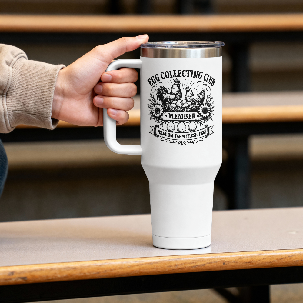 White tumbler with 'Egg Collecting Club' design held by a hand on a wooden table.