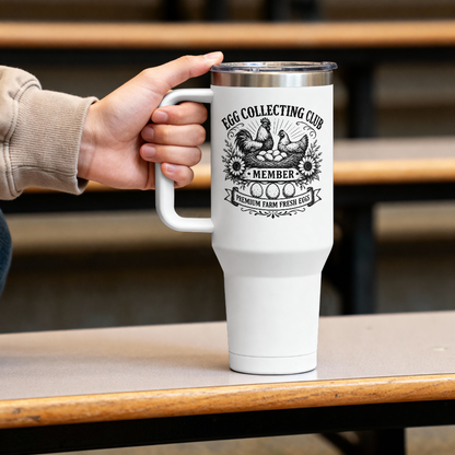 White tumbler with 'Egg Collecting Club' design held by a hand on a wooden table.