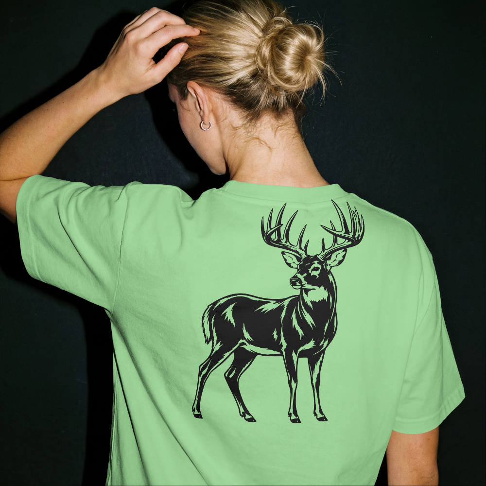 Person wearing a green t-shirt with a black deer graphic on the back against a dark background