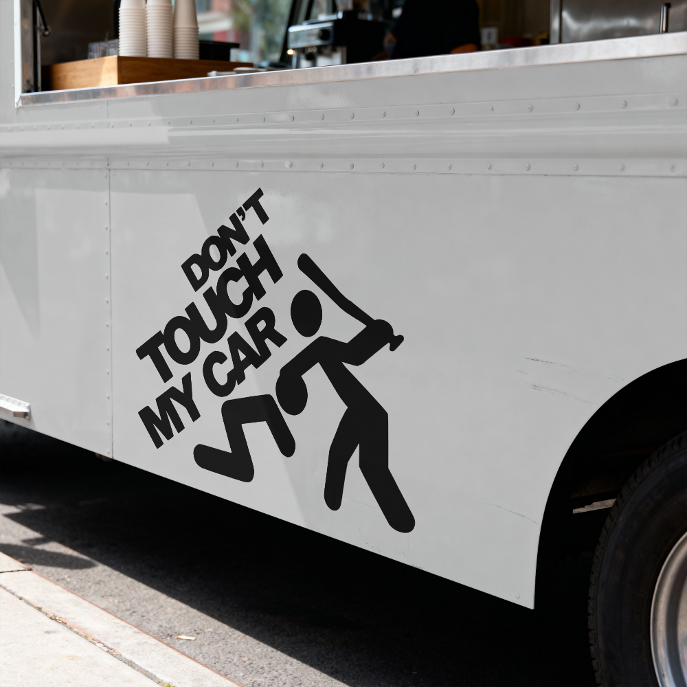 White vehicle with 'Don't Touch My Car' decal on a street