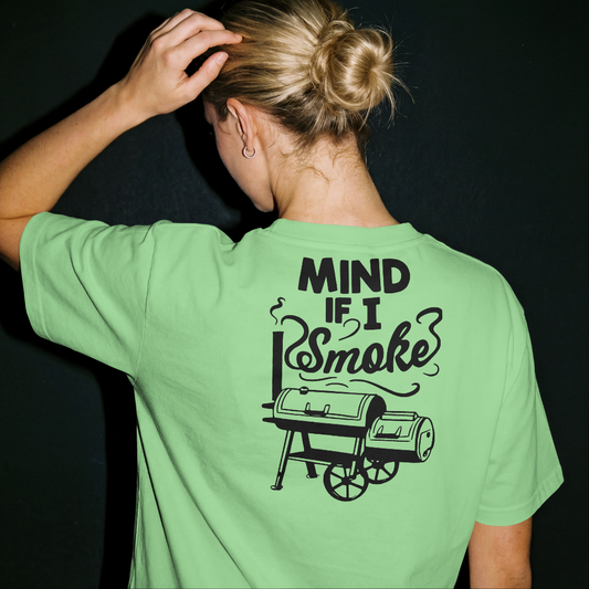 Person wearing a green t-shirt with a graphic and text on the back, against a black background