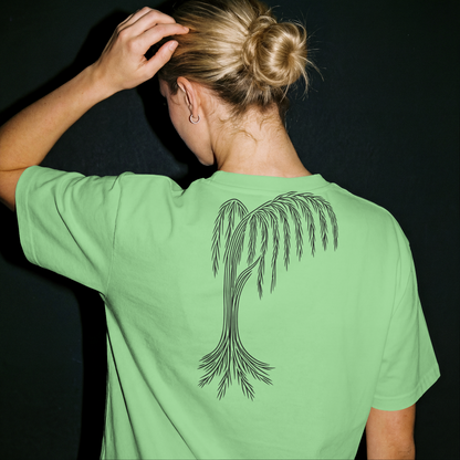 Person wearing a green t-shirt with a palm tree design on the back against a black background