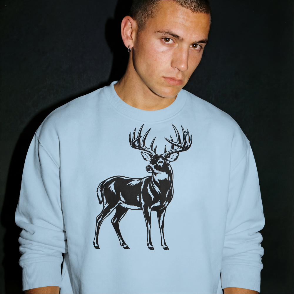 Person wearing a light blue sweatshirt with a black deer graphic on a dark background