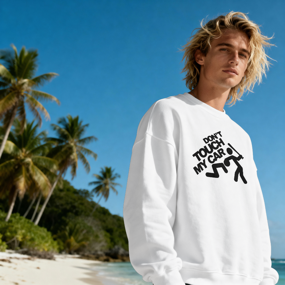 Person wearing a white sweatshirt with text on a beach with palm trees