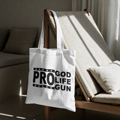 White tote bag with 'GOD PROLIFE GUN' text on a wooden chair in a room.