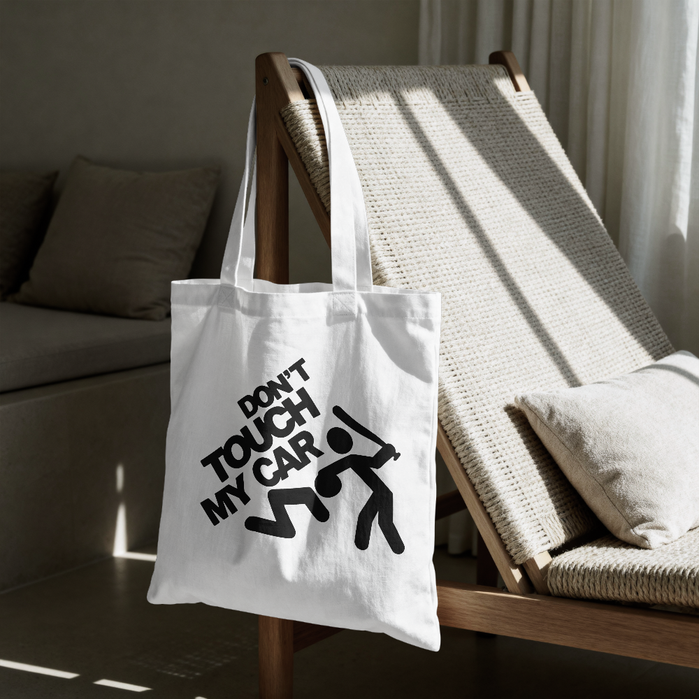 White tote bag with 'Don't Touch My Car' text on a wooden chair.