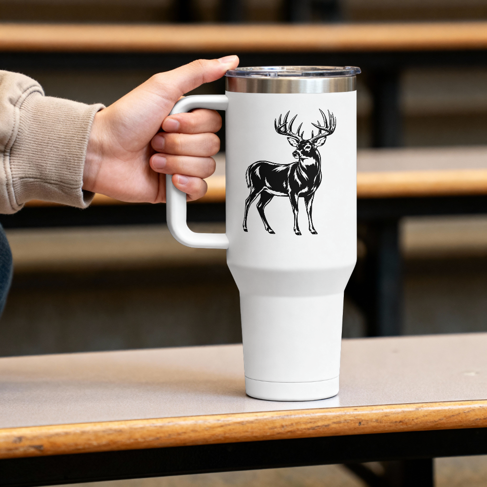 White travel mug with a black deer design held by a person on a wooden table.