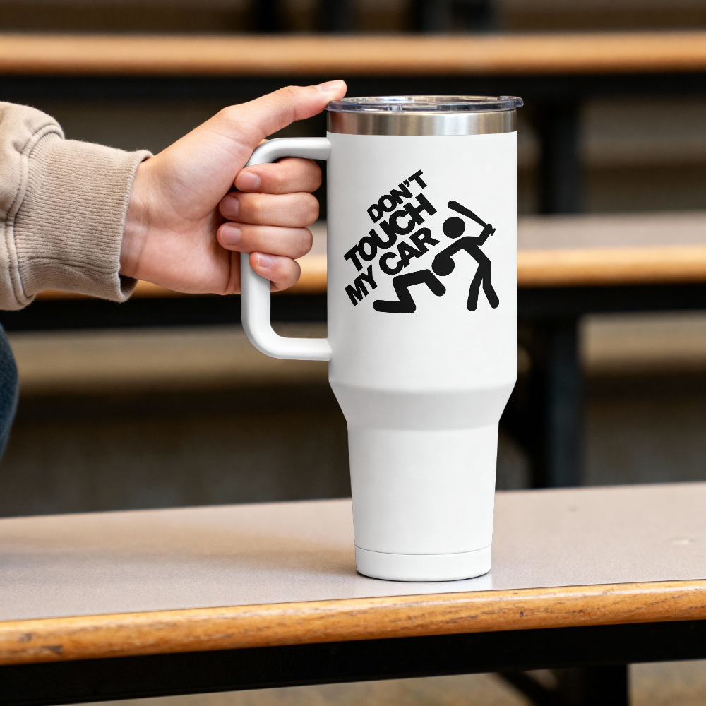 White tumbler with 'Don't Touch My Car' design held by a hand on a wooden surface.