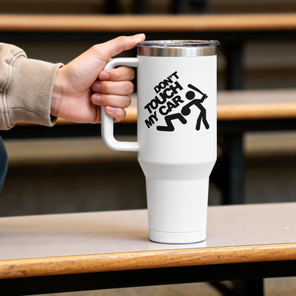 White tumbler with 'Don't Touch My Car' design held by a hand on a wooden surface.