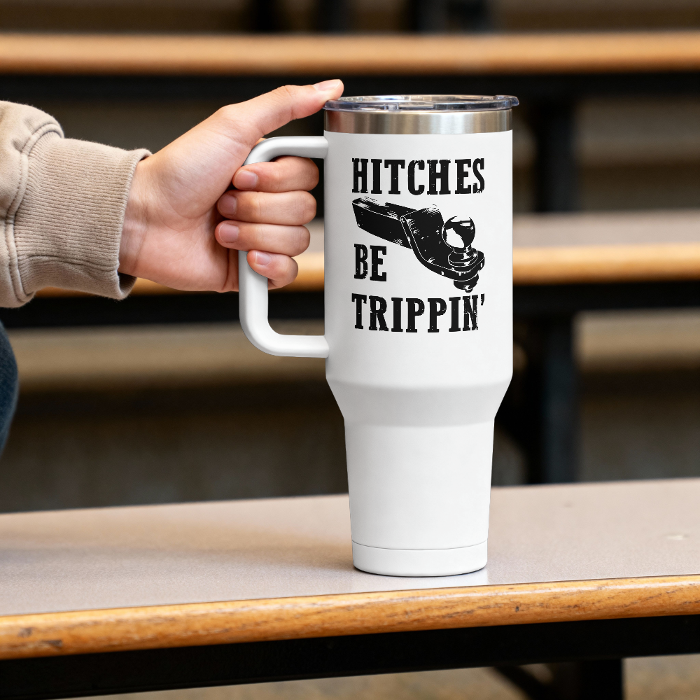 White travel mug with text and a shoe graphic held by a person on a wooden table.