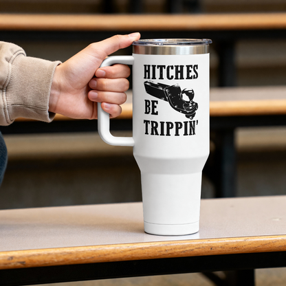 White travel mug with text and a shoe graphic held by a person on a wooden table.