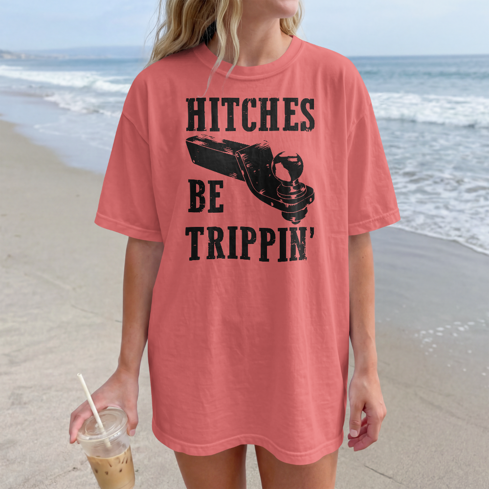 Person wearing a pink t-shirt with text and graphic on a beach