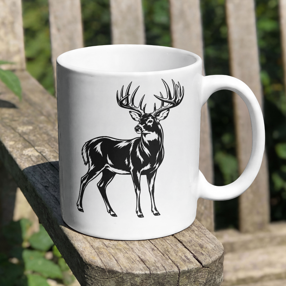 White mug with a black deer illustration on a wooden surface outdoors