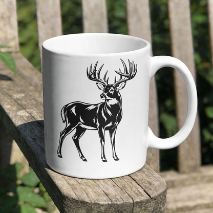 White mug with a black deer illustration on a wooden surface outdoors