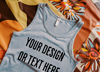 "Realistic mockup of a light gray tank top on a bright floral fabric background."